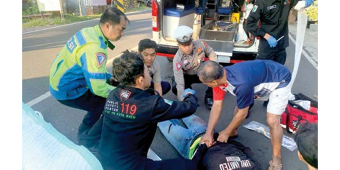 Personel Unit Gakkum Satlantas Polres Batu melakukan evakuasi terhadap korban laka di  Jalan Moh Hatta, Desa Pendem, Kecamatan Junrejo kemarin (29/4). (SATLANTAS POLRES BATU FOR RADAR MALANG)