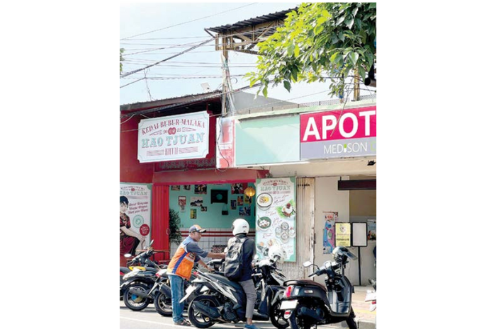 SATUAN RUANG PARKIR: Seorang jukir di Jalan Diponegoro membantu pengguna jasa parkir yang akan meninggalkan salah satu SRP di Kota Batu beberapa hari lalu. (FAJAR ANDRE SETIAWAN/RADAR BATU)