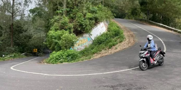TIKUNGAN CINTA: Pengendara sepeda motor melintasi arah Cangar Batu-Tikungan Gajah Mungkur di Jalur Pacet-Cangar, Rabu (9/4) (Moch. Chariris/radarmojokerto.jawapos.com).