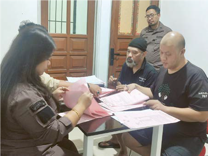LANJUT PERKARA: Kedua tersangka sedang menandatangani berkas perkara di Kantor Kejari Batu pada Kamis lalu (13/6).