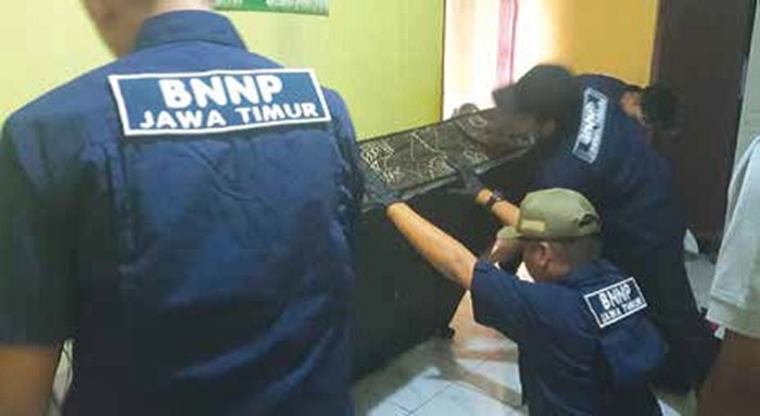 CARI NARKOTIKA: Tim dari BNNP Jawa Timur menggeledah rumah tersangka di Desa Petungsewu, Kecamatan Dau kemarin (23/6).