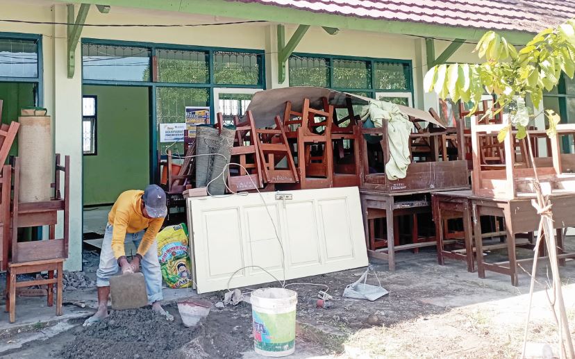 LANJUT PERBAIKAN: Seorang tukang melanjutkan renovasi kantin dan toilet MIN Batu.