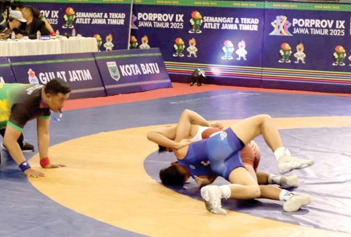 BERTANDING: Atlet gulat Kota Batu Saeful Anwar bertanding gulat nomor GR-77 kg di GOR Gajahmada pada Selasa malam lalu (1/7).