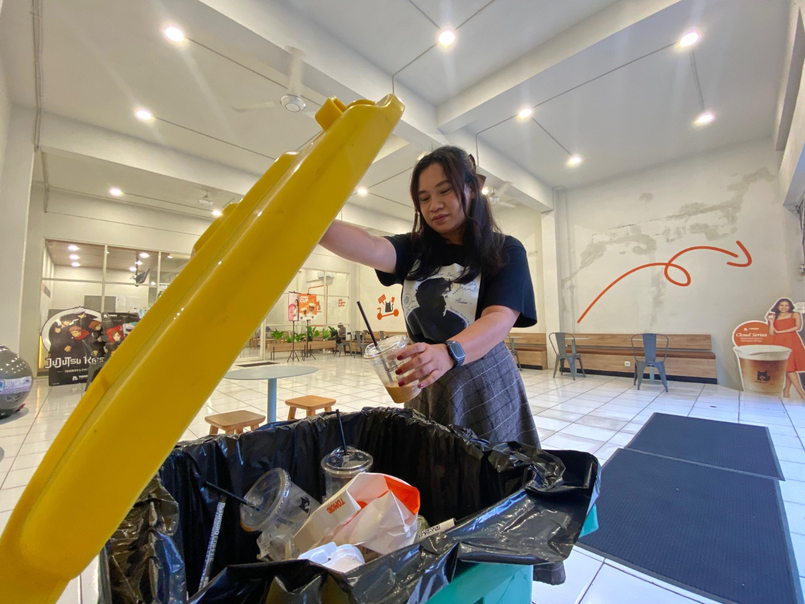 TERTIB: Salah seorang pengunjung salah satu kafe di Kecamatan Batu membuang sampah plastik kemarin (15/7).