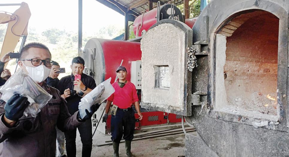DIMUSNAHKAN: Kepala Kejari Kota Batu Didik Adyotomo (kiri) akan memasukkan barang bukti untuk dimusnahkan menggunakan mesin insinerator di TPA Tlekung kemarin (17/8).