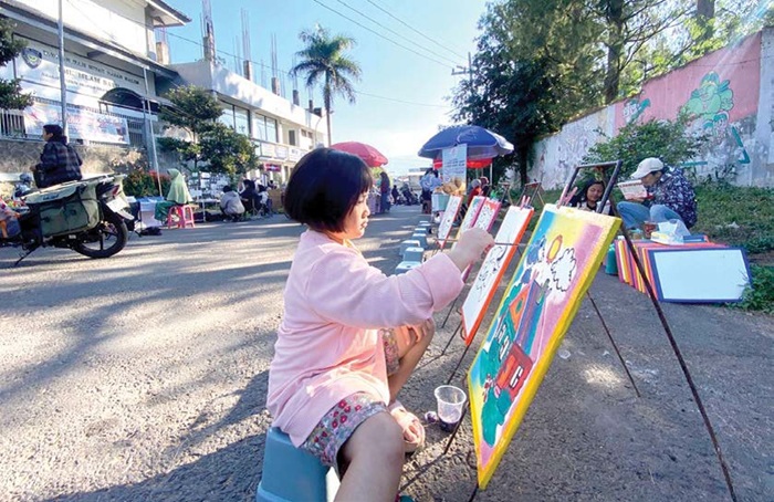 SENANG: Salah seorang anak melukis di kawasan CFD Mbatu Sae kemarin (20/7).