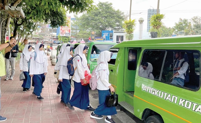 PEMINAT TINGGI: Para siswa SMP Hasyim Asyari pulang sekolah menggunakan fasilitas apel gratis jalur Batu-Songgoriti kemarin (28/7).