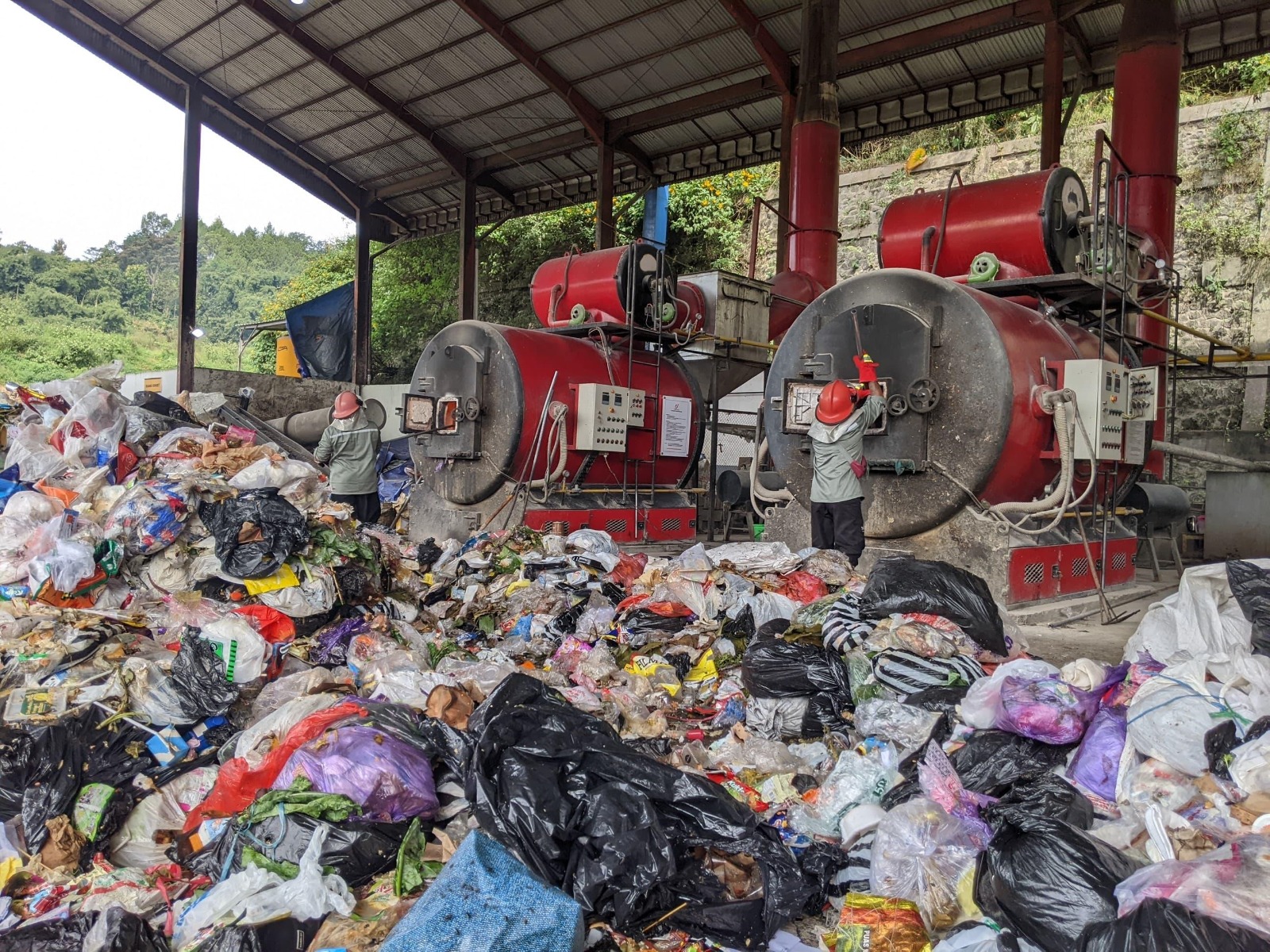 PROSES PEMBAKARAN: Beberapa petugas sampah di kawasan TPA Tlekung membakar sampah menggunakan insinerator beberapa waktu lalu.