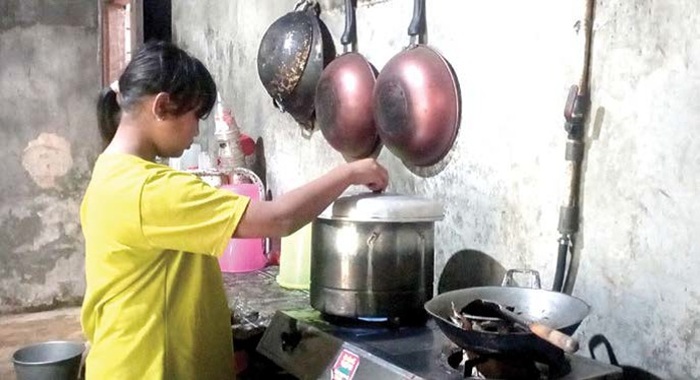 MEMASAK: Seorang warga asal Dusun Brau, Desa Gunungsari, Kecamatan Bumiaji menggunakan kompor bersumber dari biogas di rumahnya kemarin (3/8).