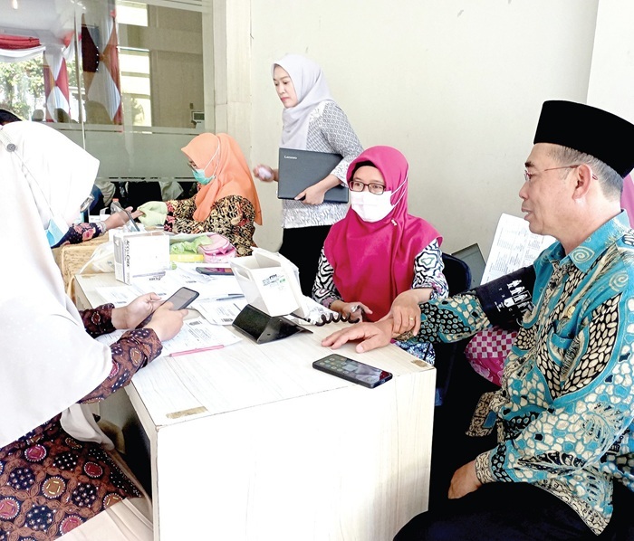 CEK KESEHETAN: Salah seorang peserta peringatan HUT Ke-50 MUI mengakses layanan Cek Kesehatan Gratis (CKG) dari Dinas Kesehatan (Dinkes) Kota Batu di Graha Pancasila kemarin (7/8).