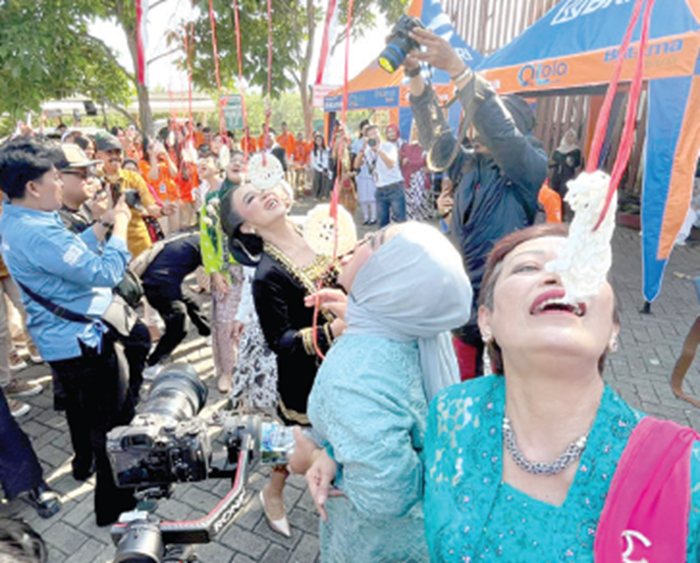 MAKAN KERUPUK: Lomba malkan kerupuk yang dikuti jajaran manajemen Jatim Park Group bikin penonton tertawa.