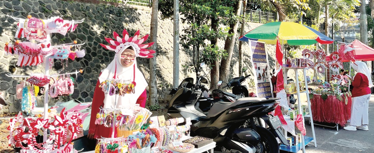 ANTUSIAS: Lilis Suryani, salah seorang Pedagang Kaki Lima (PKL) di Car Free Day (CFD) Mbatu Sae mengenakan kebaya merah dan aksesoris serba merah putih kemarin (17/8).&nbsp;