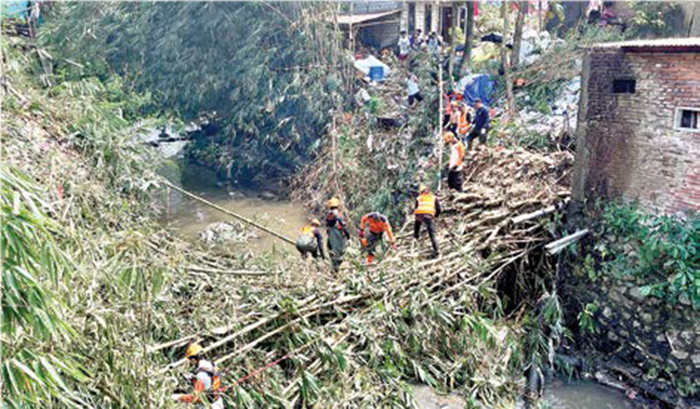KERJA BAKTI: Rumpun bambu sebanyak 50-100 batang dibersihkan petugas Badan Penanggulangan Bencana Daerah (BPBD) Kota Batu dibantu warga Jalan Bromo, Kelurahan Sisir, Kecamatan Batu kemarin (21/8).