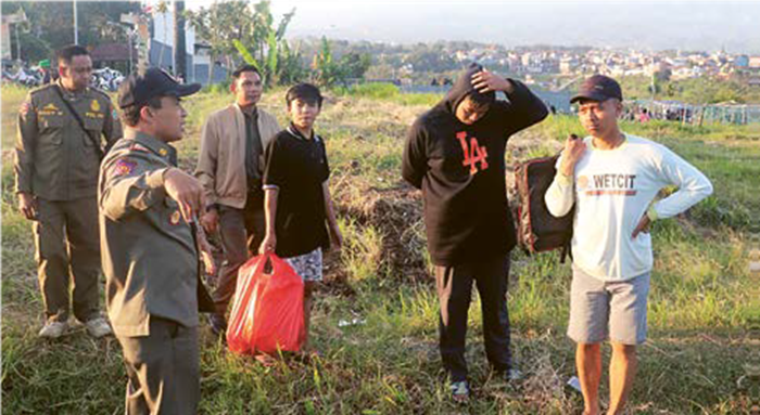 DITEGUR: Pemain layang-layang di area persawahan Kelurahan Sisir, Kecamatan Batu ditegur Satpol PP Kota Batu lantaran merusak lahan beberapa hari lalu.