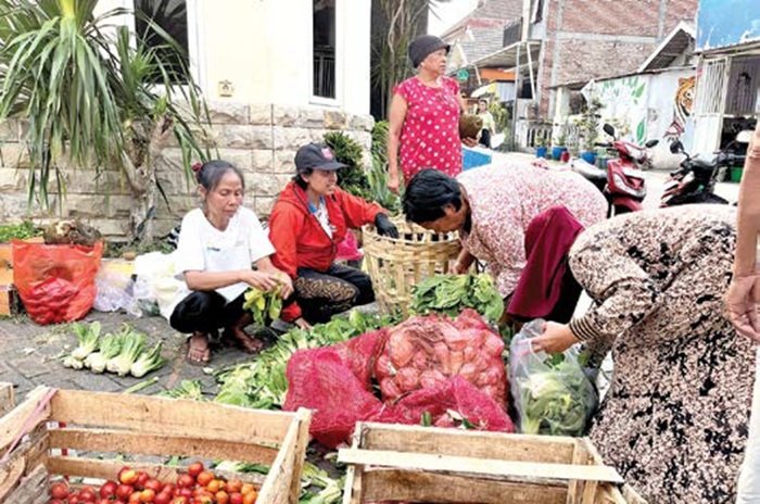 DISERBU: Warga menyerbu pedagang yang bagi-bagi sayur gratis di tepi Jalan Mojowangi, Desa Mojorejo, Kecamatan Junrejo kemarin (4/9).