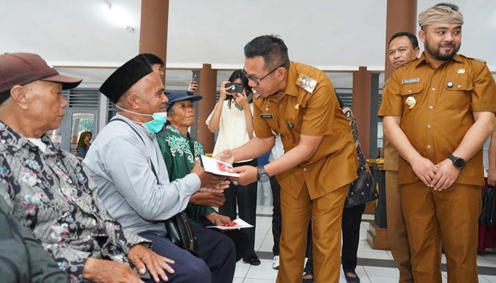SAMPAIKAN AMANAH: Wali Kota Batu Nurochman menyampaikan bantuan PKH Plus kepada salah satu warga di Pendapa Kecamatan Bumiaji, kemarin (16/9).
