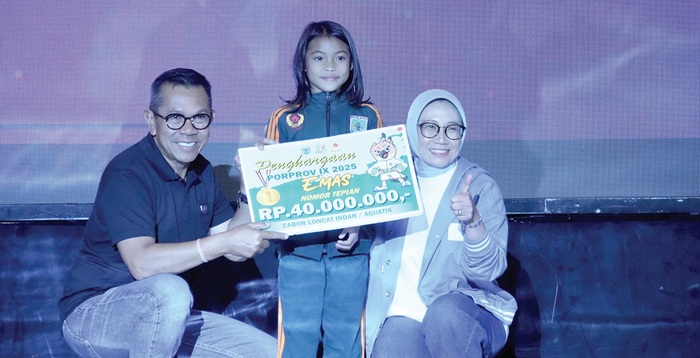 MEMBANGGAKAN: Salah seorang atlet loncat indah menerima bonus dari Wali Kota Batu Nurochman dan Ketua Tim Penggerak PKK Kota Batu Siti Faujiyah di GOR Gajahmada pada Rabu malam lalu(17/9).
