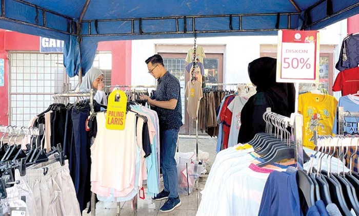 BERBELANJA: Beberapa pengunjung CFD MBatu Sae memilih-milih baju di salah satu stan kemarin (28/9).