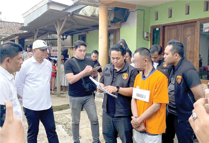GELAR REKONSTRUKSI: Terduga pelaku mempraktikkan adegan berdasarkan keterangan BAP di TKP Desa Pujon Kidul, Kecamatan Pujon, Kabupaten Malang kemarin (1/10).