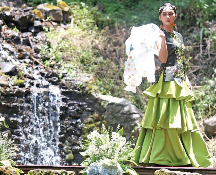 MEMUKAU: Salah seorang model memperagakan busana batik dalam Fashion on the River di Coban Putri kemarin (2/10).
