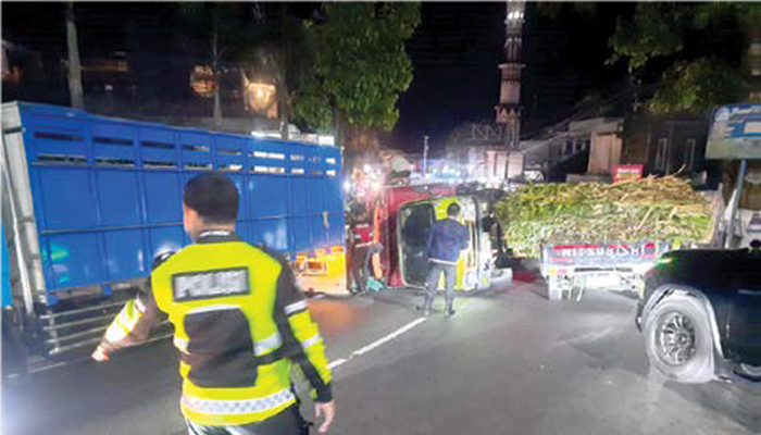 MENYEBABKAN KEMACETAN: Truk fuso terguling di sekitar Simpang Tiga Pandesari Minggu malam lalu (12/10).