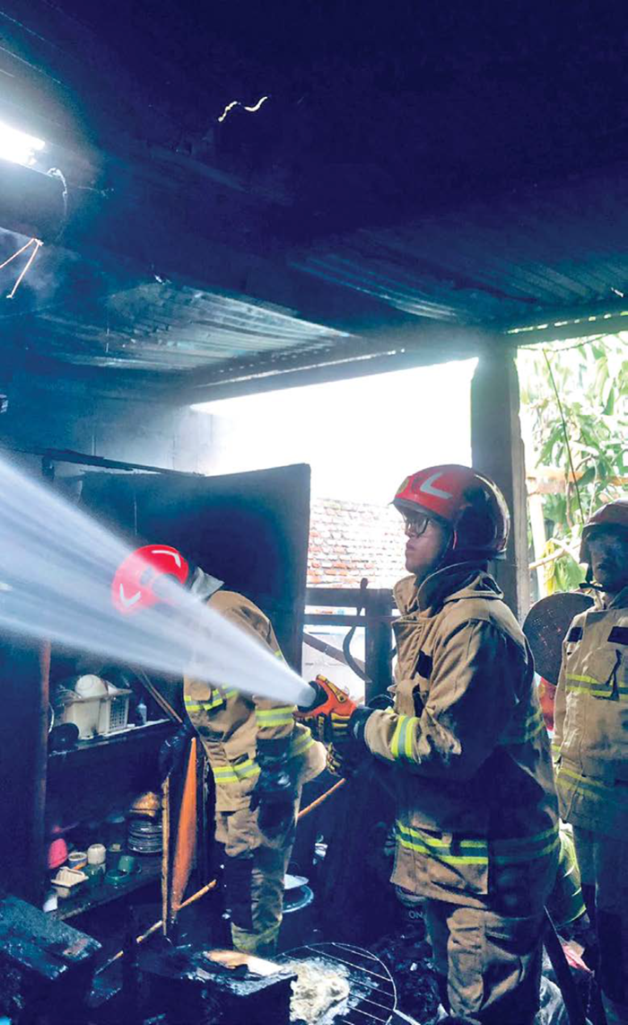 HANGUS: Petugas berupaya melakukan pendinginan setelah api yang melalap dapur Theresia Avila Octoriana, warga Jalan Sumberejo, Kecamatan Batu berhasil dipadamkan kemarin pagi (28/10).