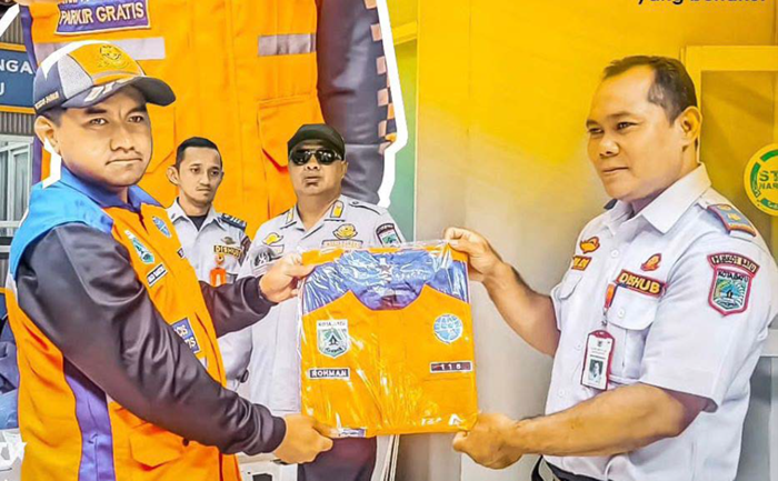 DISALURKAN: Personel Dinas Perhubungan (Dishub) menyerahkan rompi kepada perwakilan jukir kemarin (5/11).