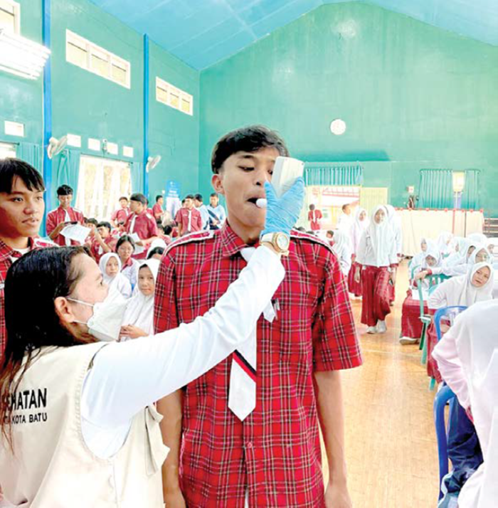 SKRINING RUTIN: Petugas Dinkes Kota Batu mengetes kandungan nikotin pada siswa SMP Negeri 3 Batu beberapa waktu lalu.