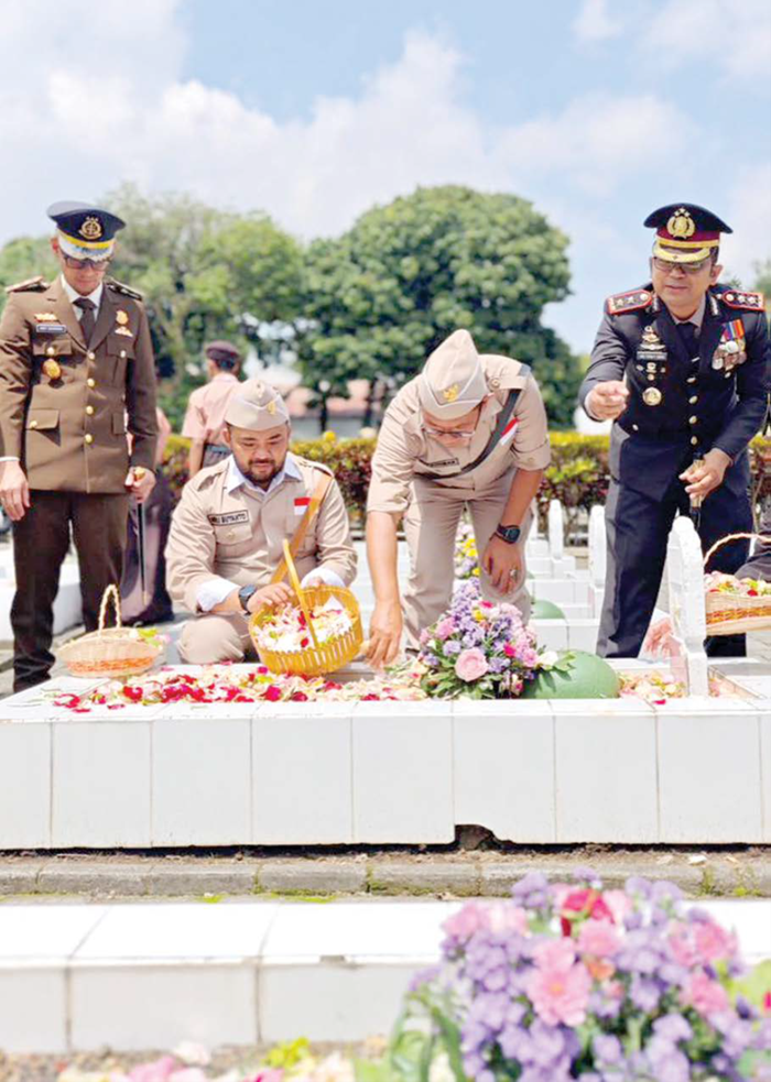 HARGAI PEJUANG: Wali Kota Batu Nurochman dan Wakil Wali Kota Batu Heli Suyanto menaburkan bunga di pusara salah seorang pahlawan di Taman Makam Pahlawan Kota Batu kemarin (10/11).