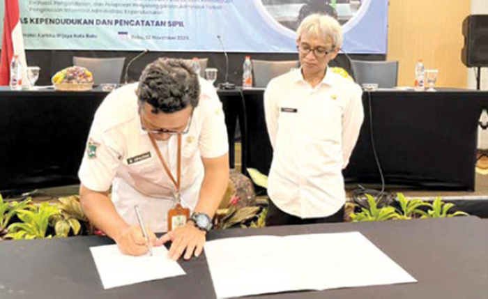 TANDA TANGAN: Penelaah Teknis Kebijakan Pemerintah Kota Batu Muchamad Awaludin menandatangani berita acara Forum Komunikasi Publik (FKP) diruang rapat el Hotel Kartika Wijaya Batu kemarin (12/11).