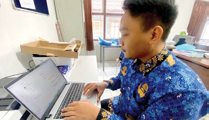 PROSES DIAKTIVASI: Kepala SRMP 14 Kota Batu Yulianah menunjukkan kiriman laptop dari Kemensos RI beberapa hari lalu.