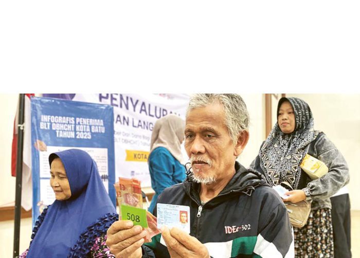 SEMRINGAH: Salah seorang warga senang usai menerima BLT DBHCHT di Kantor Desa Sidomulyo kemarin (19/11).