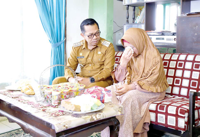 TERHARU: Keluarga Siti Khoirun Nisak, Guru Ngaji TPQ Al-Ikhlas II Punten, Kecamatan Bumiaji meneteskan air mata saat menerima santunan kematian dan beasiswa pendidikan di rumahnya kemarin (2/12).
