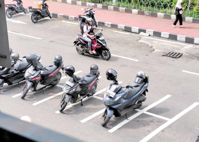 RETRIBUSI PARKIR: Petugas Dishub melakukan pengawasan parkir di kawasan pusat kota.