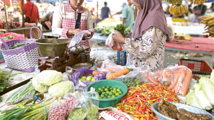 LAYANI PEMBELI: Salah seorang pedagang pasar pagi melayani pembeli kemarin (16/12). Sejumlah komoditas mengalami kenaikan harga menjelang momentum libur Nataru.