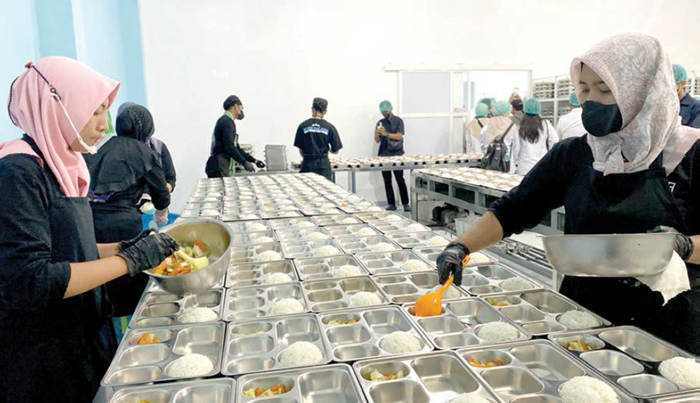 KANTONGI LEGALITAS: Karyawan SPPG Sulaiman Al Haj, Kelurahan Dadaprejo, Kecamatan Junrejo menata makanan beberapa waktu lalu.