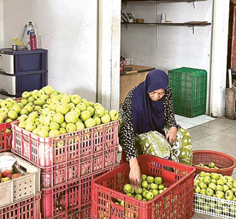 STOK APEL: Salah satu penjual apel di zona apel Pasar Induk Among Tani menjajakan dagangannya kemarin (17/12).