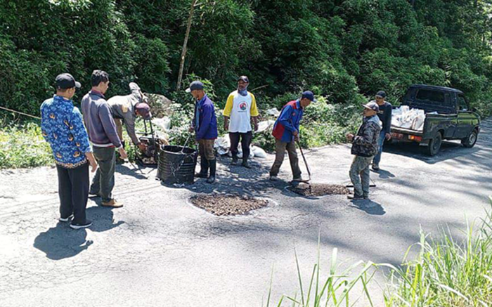 PROSES PENAMBALAN: Petugas Dinas PUPR Kota Batu menambal jalan berlubang di Jalur Klemuk, Kelurahan Songgokerto beberapa waktu lalu.