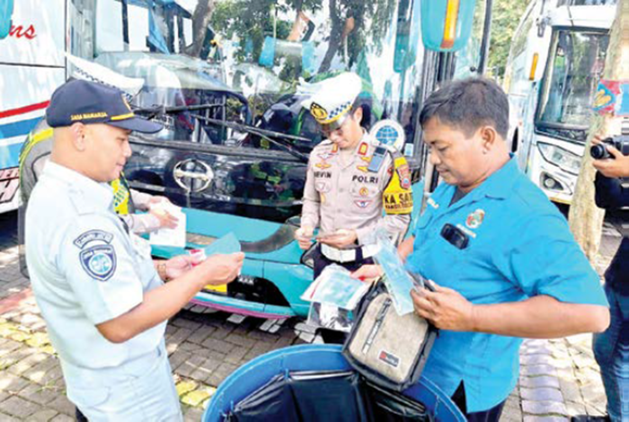 TERTIB: Petugas gabungan mengecek kelengkapan administrasi dan kelaikan kendaraan yang terparkir di Jatim Park 1 kemarin (23/12).