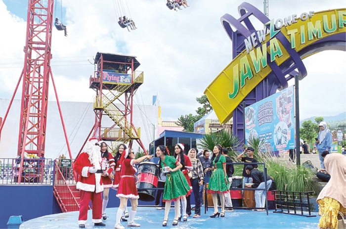 BERI HADIAH: Salah seorang pengunjung berkesempatan mendapatkan hadiah saat pertunjukan Santa in The Town di Jawa Timur Park 1 kemarin (25/12).