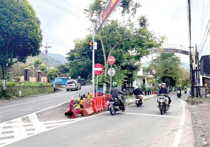MELANGGAR ATURAN: Tiga pengemudi motor nekat melawan arus di Jalan Arumdalu, Desa Songgokerto, Kecamatan Batu beberapa waktu lalu.