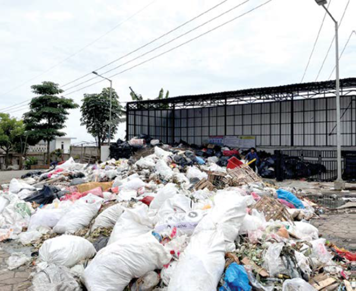 MENUMPUK: Sampah di TPS Pasar Induk Among Tani tampak meluber ke jalan sejak pekan lalu hingga kemarin (28/12).
