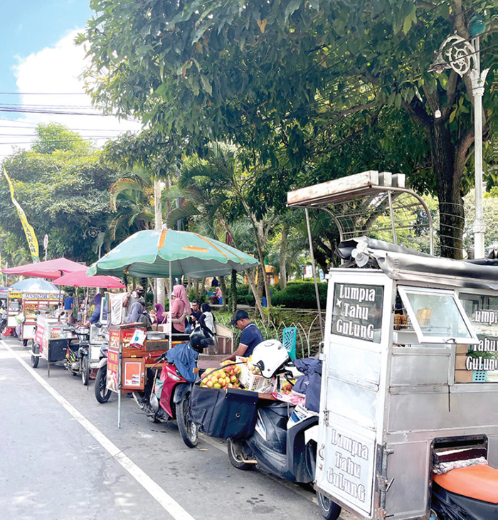DIPADATI PKL LIAR: Tepi jalan raya di sekitar area Alun-Alun Kota Wisata Batu (KWB) tampak leluasa dijadikan tempat mangkal oknum Pedagang Kaki Lima (PKL) liar kemarin (29/12).