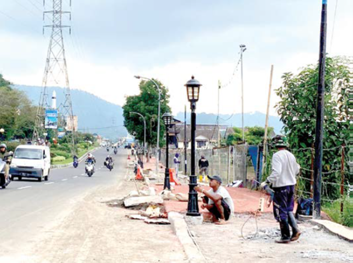 PROSES PEMASANGAN: Beberapa petugas DPUPR Kota Batu memasang lampu kota di Jalan Sultan Agung, Kecamatan Batu pada Jumat lalu (2/1).