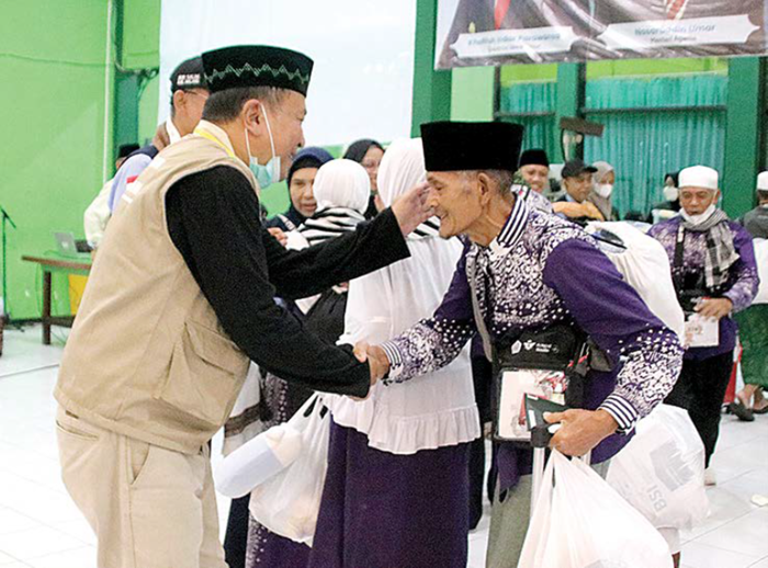 SEMRINGAH: Salah seorang jemaah haji 2025 asal Kota Batu disambut Kepala Seksi Penyelenggaraan Haji dan Umrah atau PHU (kini Kemenhaj) Kota Batu Basuki Rahmat setelah selesai menunaikan ibadah haji