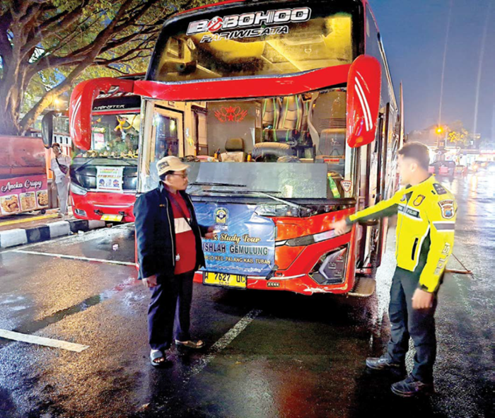 DIAMANKAN: Petugas mengamankan bus yang terlibat laka di Jalur Payung alias Jalan Raya Trunojoyo, Kelurahan Songgokerto, Kecamatan Batu dini hari kemarin (14/1).