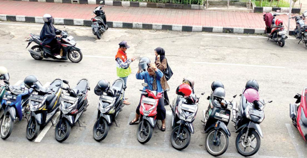 LAYANI PENGUNJUNG: Jukir di Alun-Alun Kota Wisata Batu menarik karcis parkir secara manual pada 13 Januari lalu.