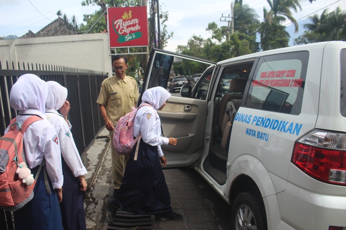 BERKORBAN: Salah satu guru SMPN Satu Atap Pesanggrahan 2 Batu, Erris Kurniawan, dalam perjalanan antar-jempus siswa beberapa hari lalu.