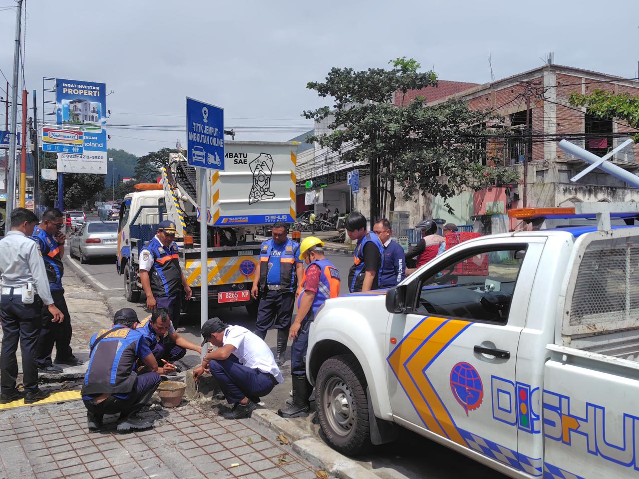 BERI TANDA: Dishub Kota Batu, Organda, dan Aliansi Ojol memasang rambu penjemputan di Jalan Dewi Sartika kemarin (26/1).