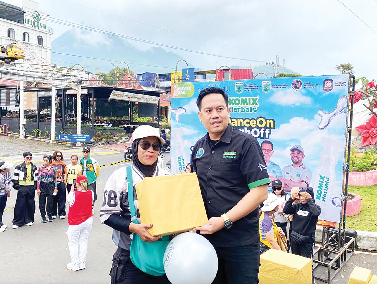 FULL SENYUM: Salah seorang peserta senam zumba CFD Mbatu Sae menerima hadiah dari Komix Herbal kemarin (1/2).